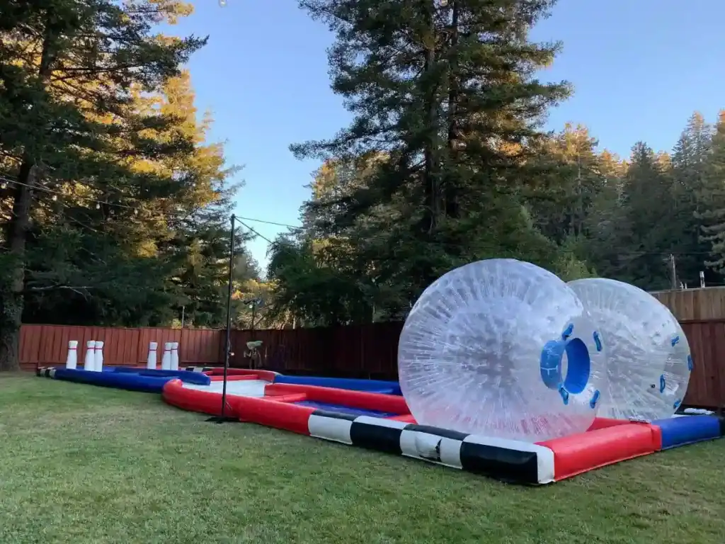 Inflatable zorb balls on an outdoor track set up on a grassy lawn
