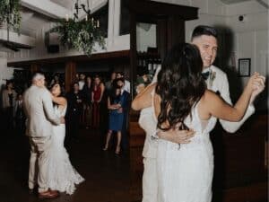 Bride and groom sharing their romantic first dance at a wedding reception, surrounded by guests. The bride wears a lace gown, and the groom is in a beige suit. The atmosphere is joyful and intimate.