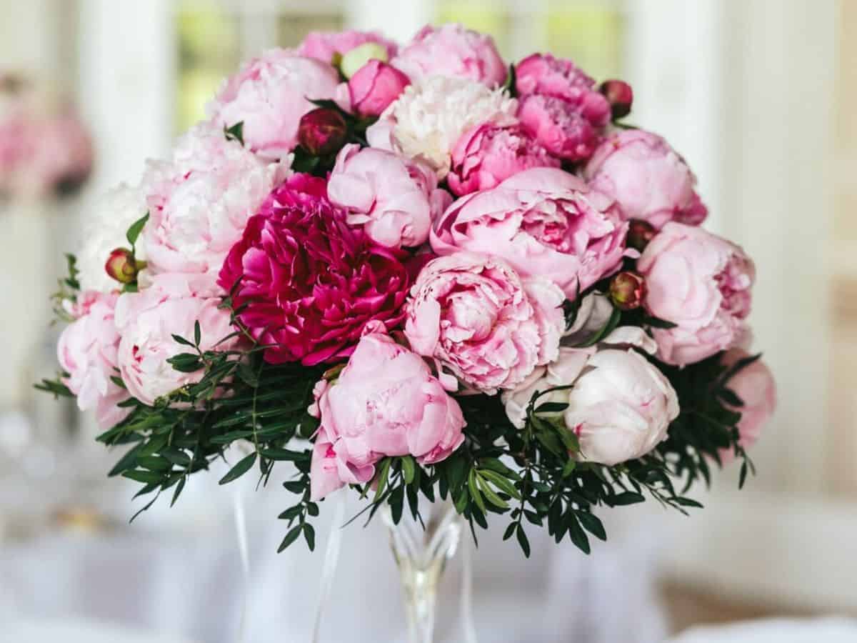 Soft pink and pink peonies arranged as table decor for a wedding