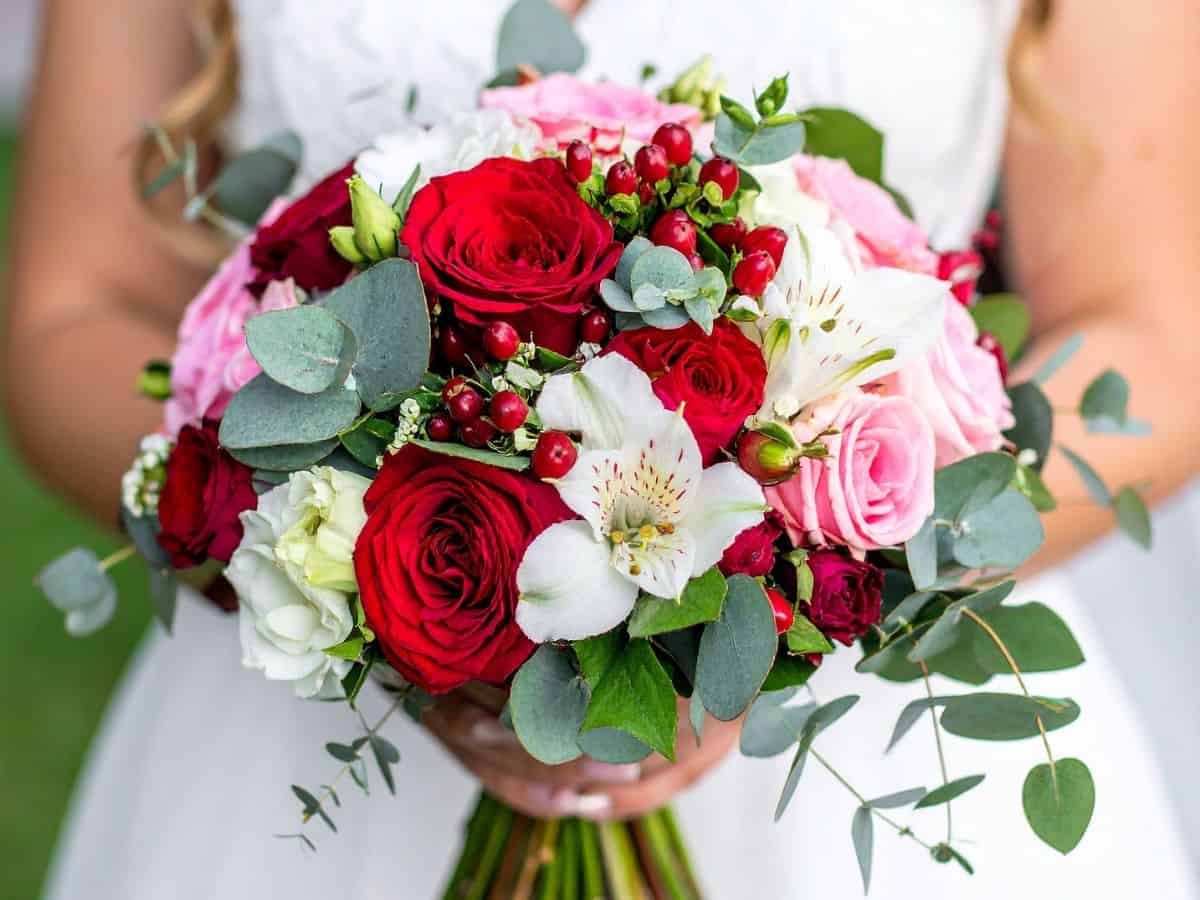 Bride holding a bouquet of red roses on her wedding day