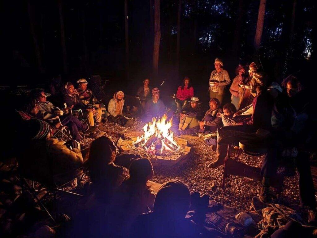 Outdoor bachelor party with friends enjoying a nighttime campfire.
