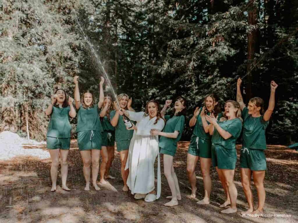 Bride and bridesmaids cheering outdoors before wedding