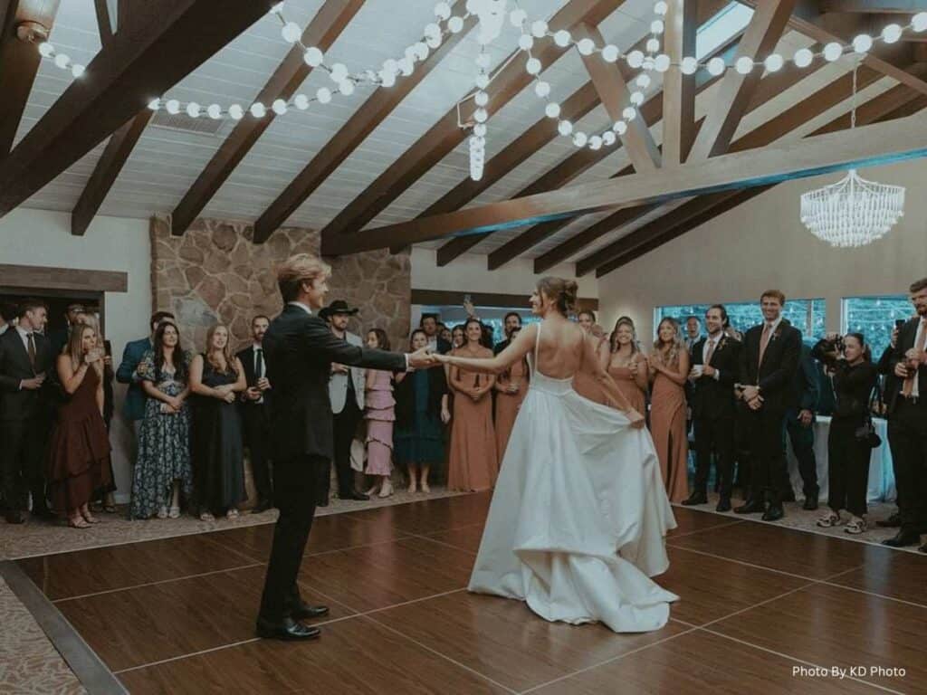 Bride and groom dancing beneath string lights
