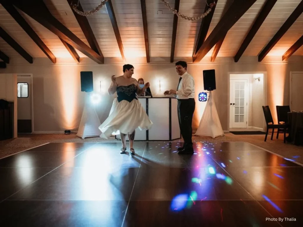 Bride and groom dancing at wedding reception with DJ lights