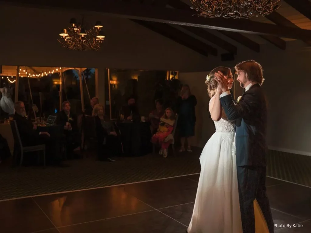 Bride and groom sharing a romantic first dance at a wedding reception in warm lighting