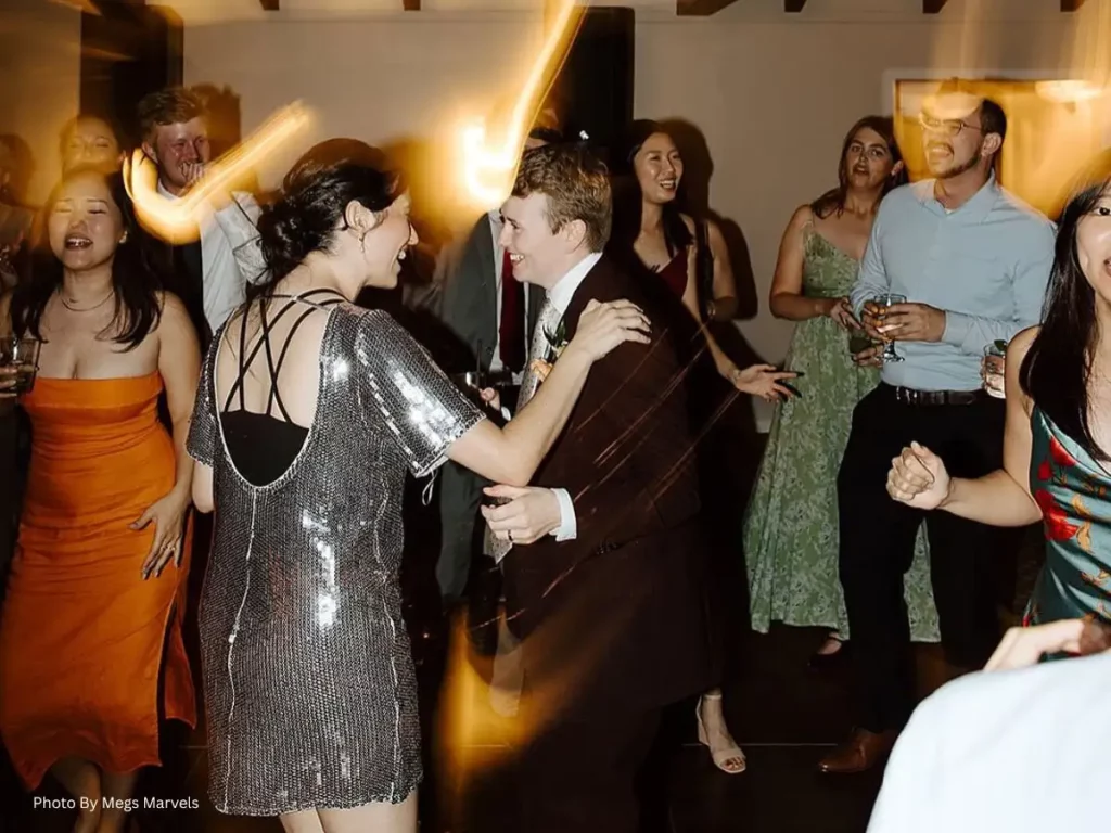 Wedding couple dancing with guests enjoying a lively wedding reception party